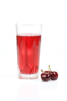 Glass with cherry juice and cherries. Isolated on a white background