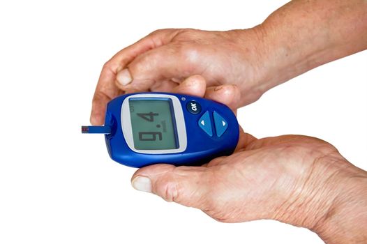 Blue meter with readings of blood sugar in the hands of an elderly woman isolated on white background