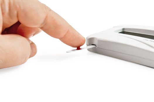 White instrument for measuring glucose levels with test strips, hand and drop of blood is isolated on a white background