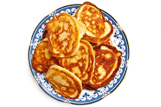 Golden pancakes on porcelain plate isolated on white background