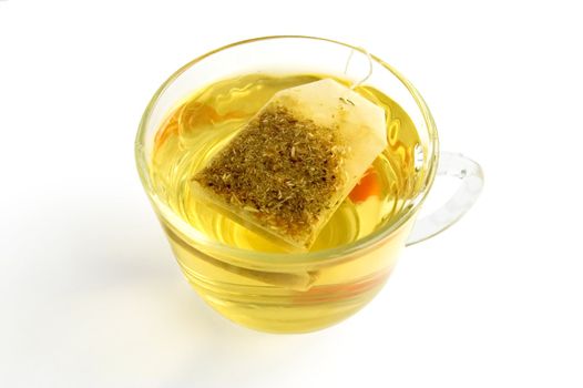 The bag of green herbal tea in a glass bowl with water, isolated on a white background