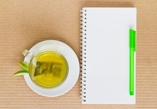 Green tea in a white cup on a paper background