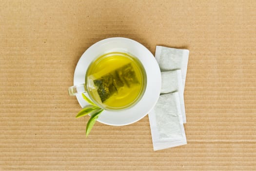 Green tea in a white cup on a paper background