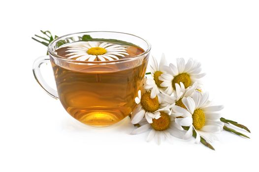 Herbal tea in glass cup with chamomile, a bouquet of daisies and grass isolated on white background