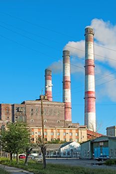 Pipes and building hydropower plants on the background of blue sky in the town of Serov