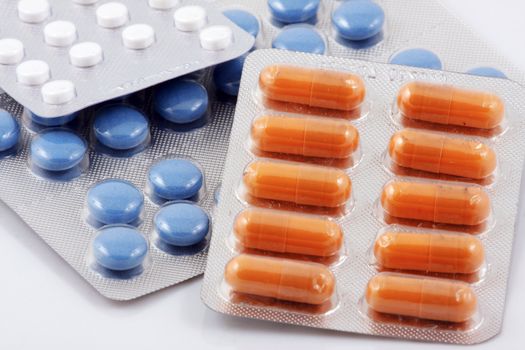 Pills of many shapes and colors grouped together