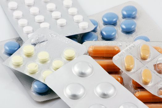 Pills of many shapes and colors grouped together