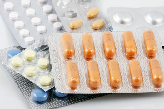 Pills of many shapes and colors grouped together