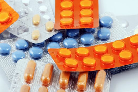 Pills of many shapes and colors grouped together