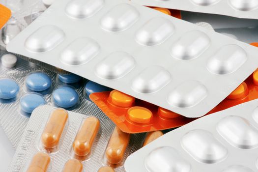 Pills of many shapes and colors grouped together