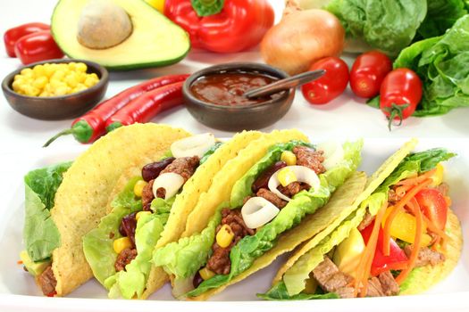 Taco shells filled with ground beef, kidney beans and corn