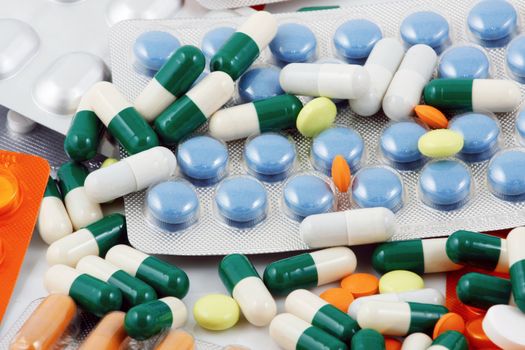 Pills of many shapes and colors grouped together