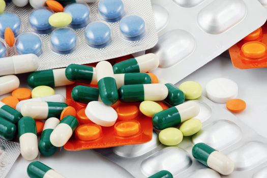 Pills of many shapes and colors grouped together