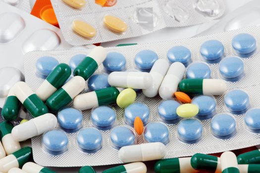 Pills of many shapes and colors grouped together
