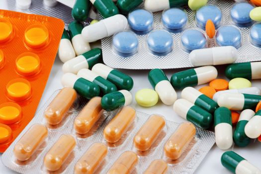 Pills of many shapes and colors grouped together