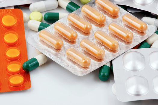 Pills of many shapes and colors grouped together