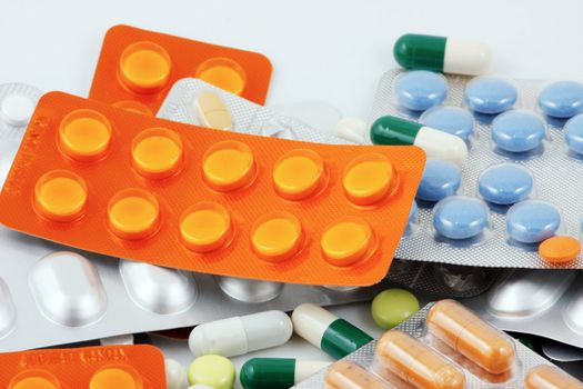 Pills of many shapes and colors grouped together