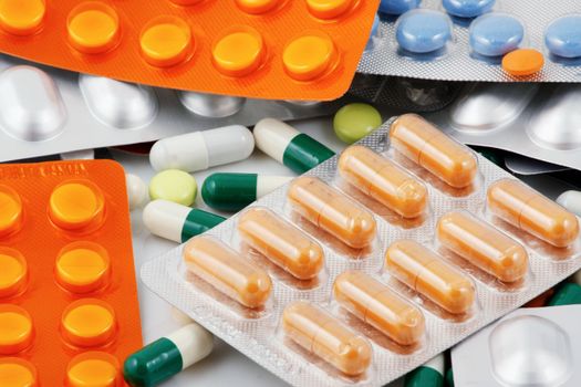 Pills of many shapes and colors grouped together