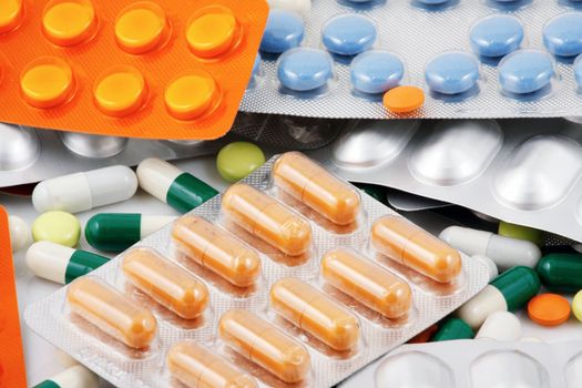 Pills of many shapes and colors grouped together