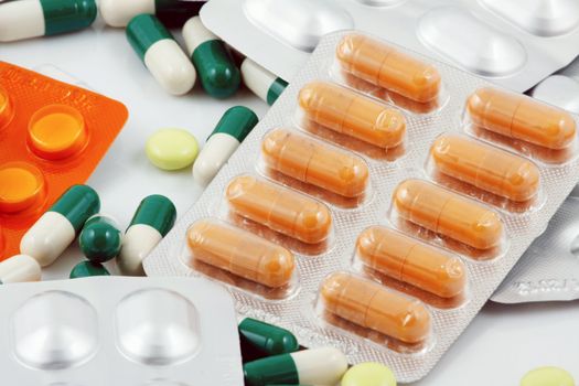 Pills of many shapes and colors grouped together