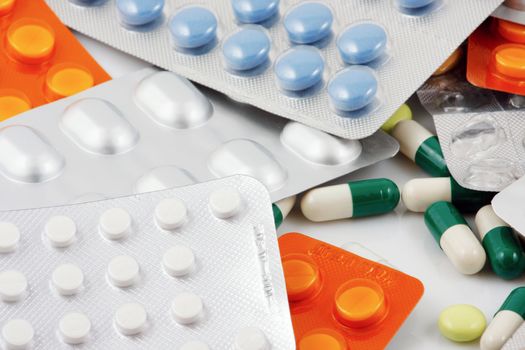 Pills of many shapes and colors grouped together