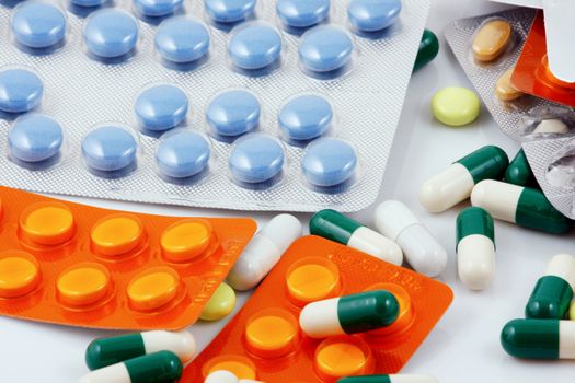 Pills of many shapes and colors grouped together