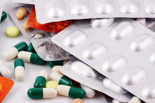 Pills of many shapes and colors grouped together