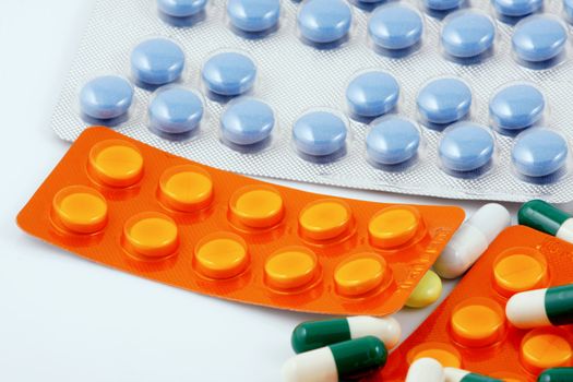 Pills of many shapes and colors grouped together