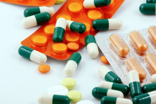 Pills of many shapes and colors grouped together
