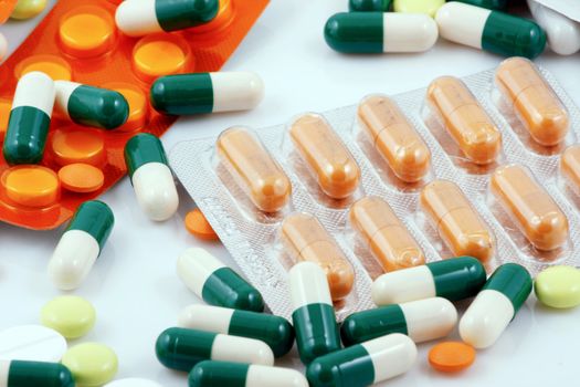 Pills of many shapes and colors grouped together