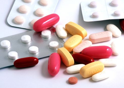 Pills of many shapes and colors grouped together