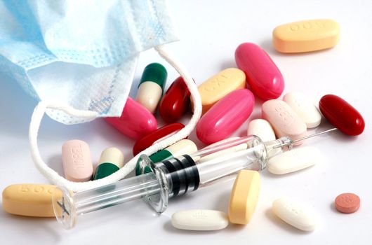 Pills of many shapes and colors grouped together