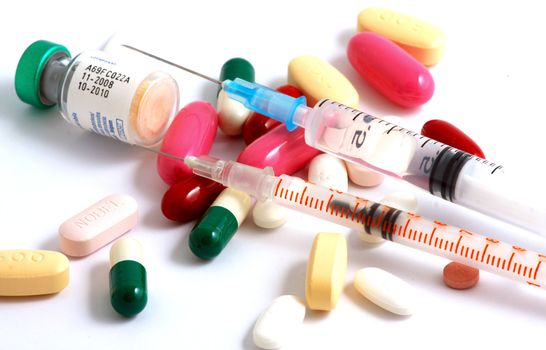 Pills of many shapes and colors grouped together