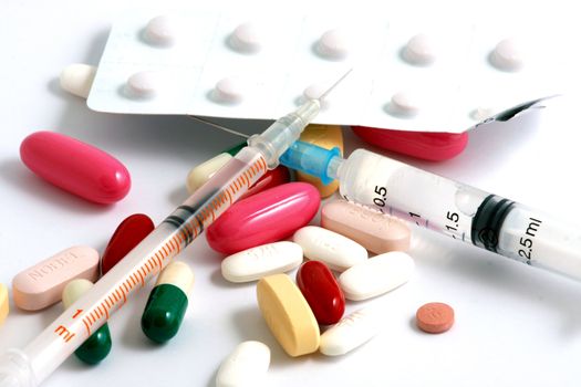 Pills of many shapes and colors grouped together