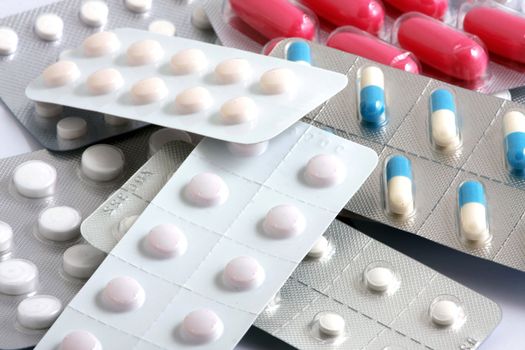 Pills of many shapes and colors grouped together