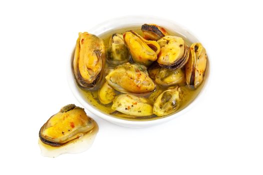 Mussels with spices and oil in a dish isolated on white background