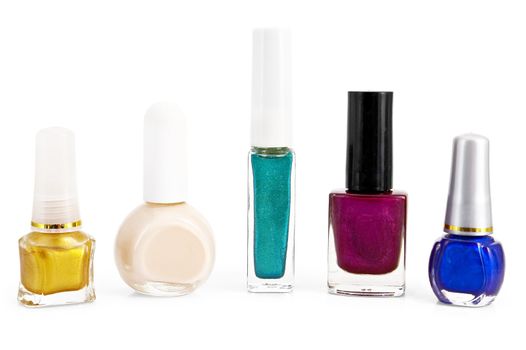A number of different bottles with colored nail polish is isolated on a white background