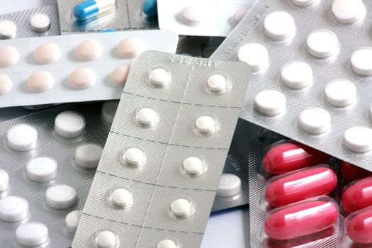 Pills of many shapes and colors grouped together