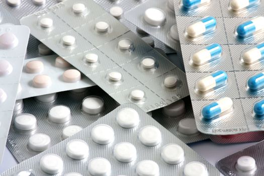 Pills of many shapes and colors grouped together