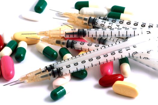 Pills of many shapes and colors grouped together
