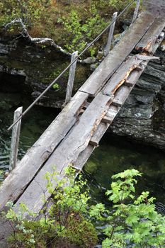Dangerous old wooden bridge across a river