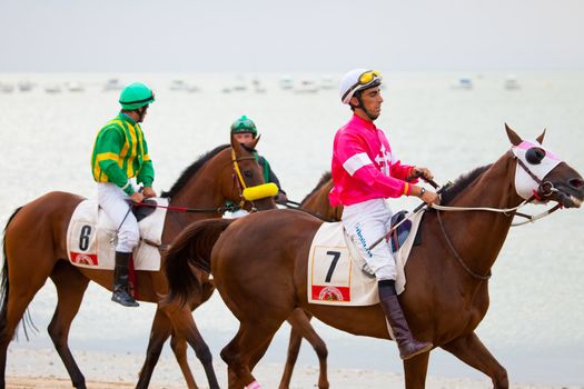 SANLUCAR DE BARRAMEDA, CADIZ, SPAIN - AUGUST 07: Unidentified riders at the start of race horses on Sanlucar de Barrameda beach on  August 07, 2010 in Sanlucar de Barrameda, Cadiz, Spain.