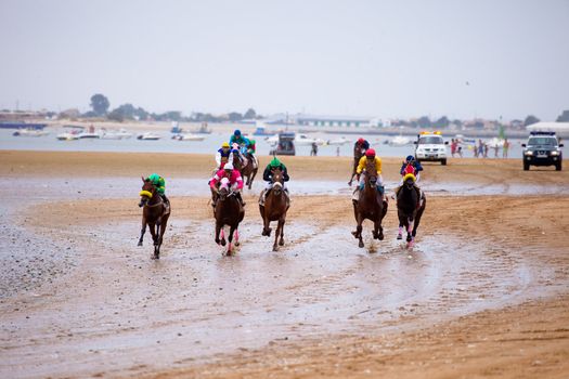 SANLUCAR DE BARRAMEDA, CADIZ, SPAIN - AUGUST 07: Unidentified riders at the start of race horses on Sanlucar de Barrameda beach on  August 07, 2010 in Sanlucar de Barrameda, Cadiz, Spain.