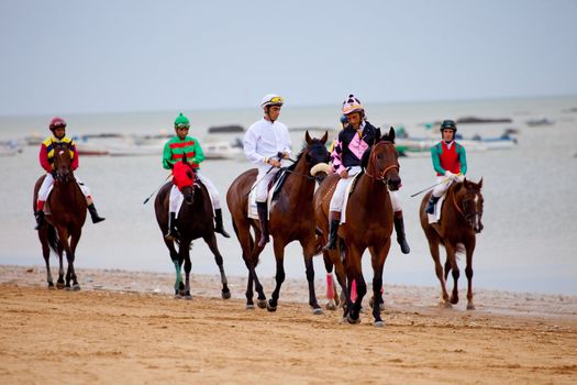 SANLUCAR DE BARRAMEDA, CADIZ, SPAIN - AUGUST 07: Unidentified riders at the start of race horses on Sanlucar de Barrameda beach on  August 07, 2010 in Sanlucar de Barrameda, Cadiz, Spain.