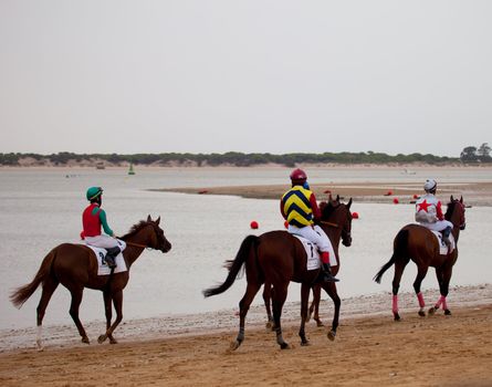 SANLUCAR DE BARRAMEDA, CADIZ, SPAIN - AUGUST 07: Unidentified riders at the start of race horses on Sanlucar de Barrameda beach on  August 07, 2010 in Sanlucar de Barrameda, Cadiz, Spain.