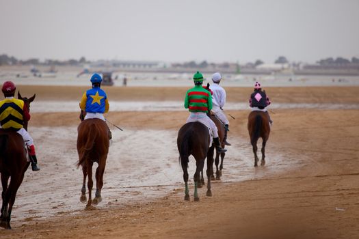 SANLUCAR DE BARRAMEDA, CADIZ, SPAIN - AUGUST 07: Unidentified riders at the start of race horses on Sanlucar de Barrameda beach on  August 07, 2010 in Sanlucar de Barrameda, Cadiz, Spain.