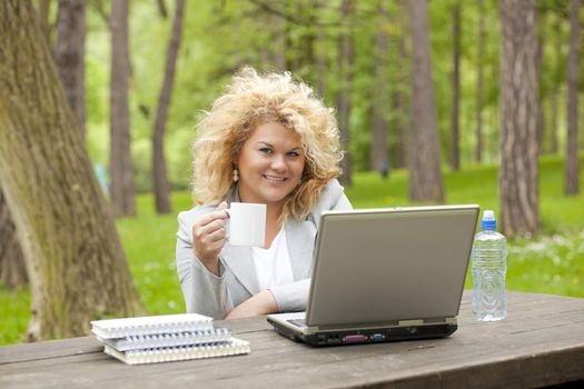 Young woman using laptop in park