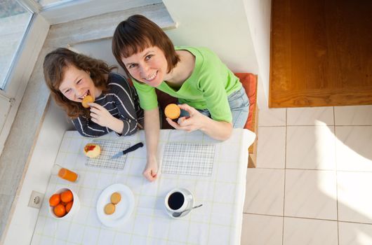 Daughter and her mom having a breakfast together. High angle view.