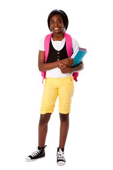 Beautiful happy student girl with colorful notebooks and backpack ready for school, isolated.