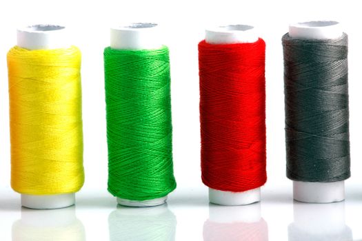 Set of colorful spools of thread isolated on white background